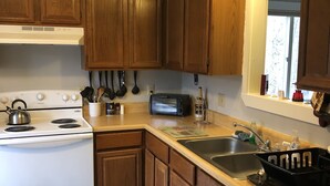 A kitchen with wooden cabinets, a white stove, a sink, and a dishwasher. - Great Location, walk to the Flume 1.5 mi and trailheads (Lincoln)
