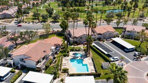 Quartiere residenziale con piscina, diverse case e auto parcheggiate.