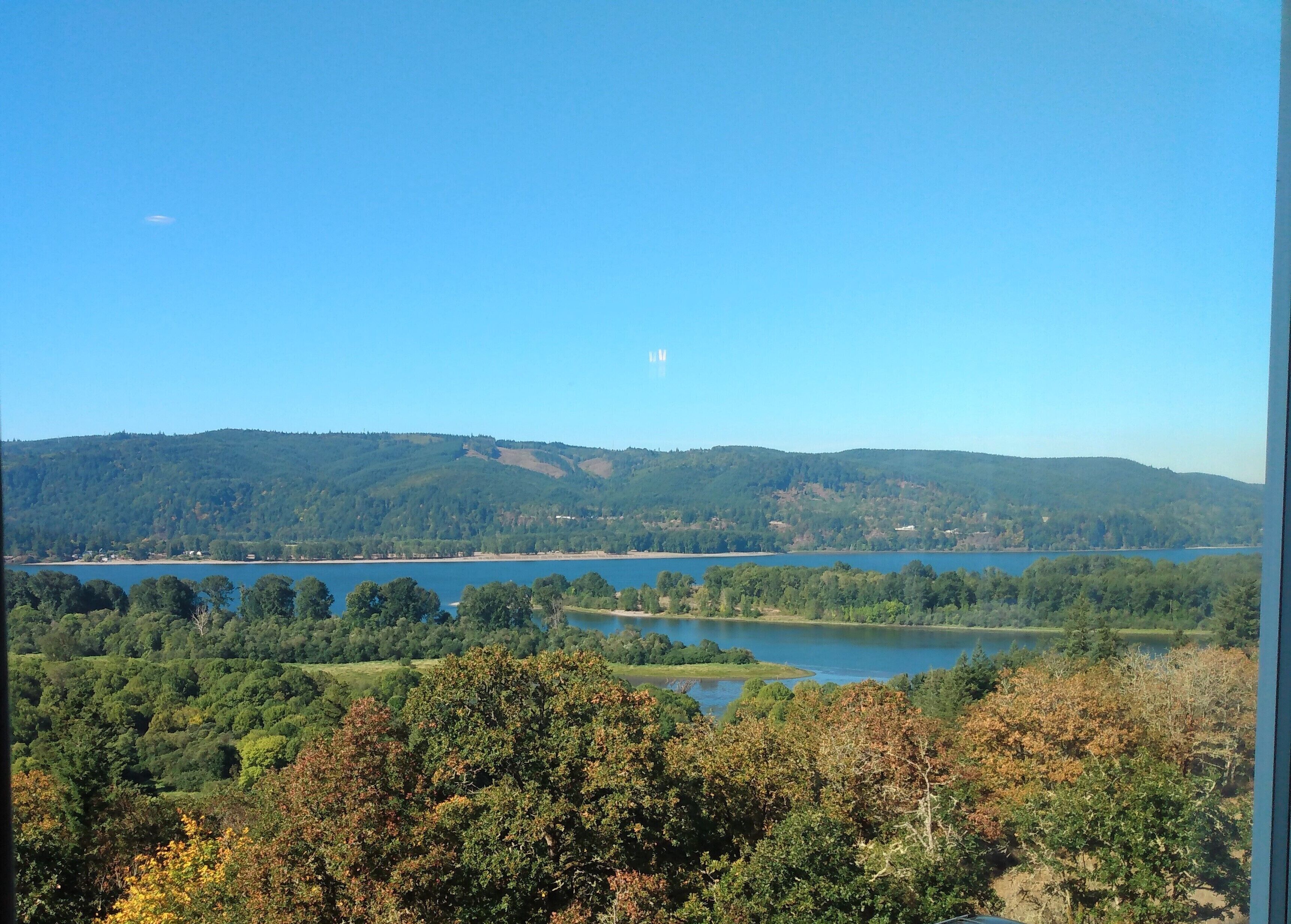 A view of a lake surrounded by hills and trees.