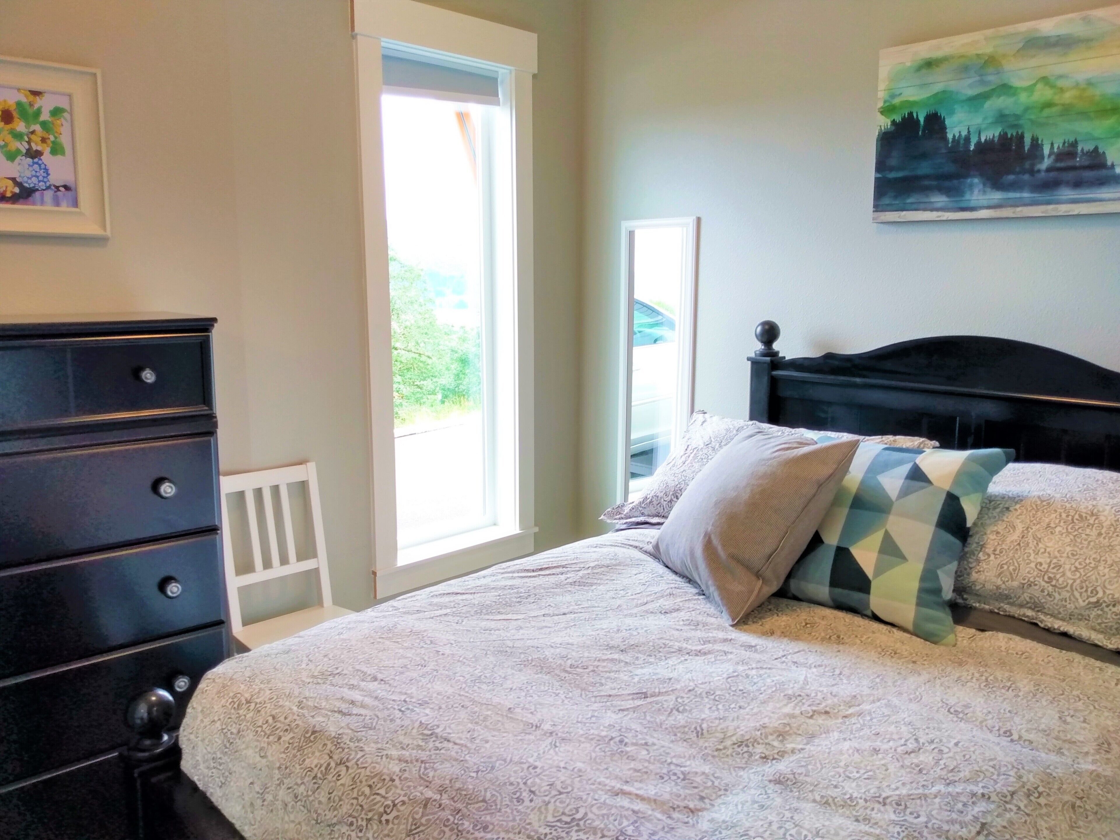 Un dormitorio con cama, cómoda y un cuadro en la pared.