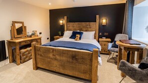A bedroom with a wooden bed, bedside tables, a chair, and a desk. - Bulls Head - Holymoorside (Chesterfield)
