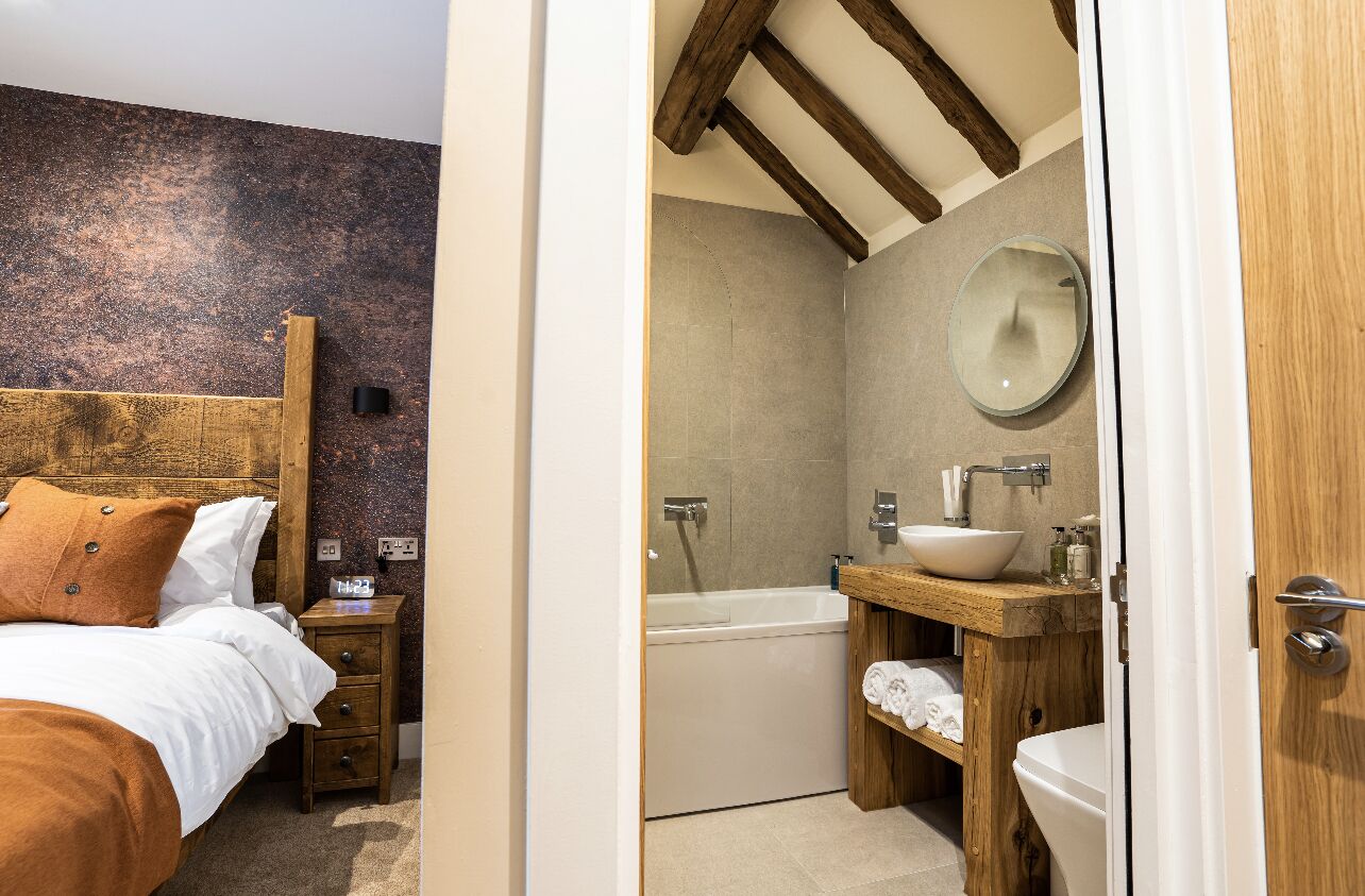 A bedroom with a wooden headboard, a bedside table, and a nightstand.