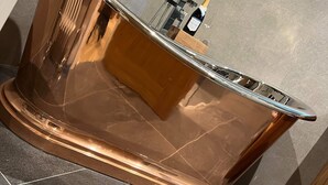 A copper-toned bar area with a built-in wine cooler and a bottle of champagne. - Bulls Head - Holymoorside (Chesterfield)