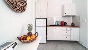 Una cocina moderna con armarios blancos, salpicadero de mármol y encimera de madera.