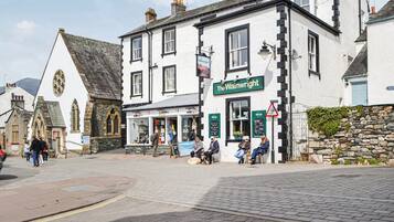 A traditional pub named 'The Wainwright' with a stone facade, multiple windows, and a signboard.