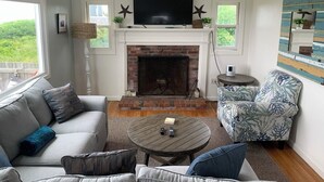 A living room with a fireplace, a television, and a sofa.