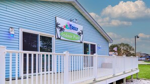A blue building with a sign for 'Reef Vacation Villas' and an 'Indoor Pool'. - Sand Dollar Villa (Chincoteague)