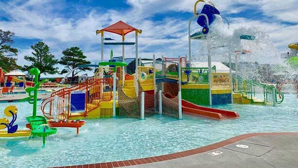 A water park with a play structure, slides, and a pool. - Sand Dollar Villa (Chincoteague)