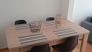 A dining table with four black chairs, two woven chairs, and striped placemats. - Charming Mersoise house 7 minutes walk from the beach with private covered parking (Mers-les-Bains)