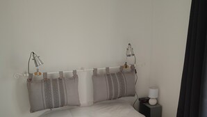 A neatly made bed with a white duvet, grey pillows with patterned designs, and two bedside lamps on a nightstand. - Charming Mersoise house 7 minutes walk from the beach with private covered parking (Mers-les-Bains)