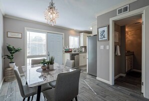 Enjoy meals at the dining table with island and stainless steel refrigerator.