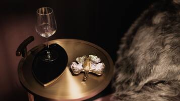 A close-up of a vinyl record player with a glass of wine and a decorative item on a table.