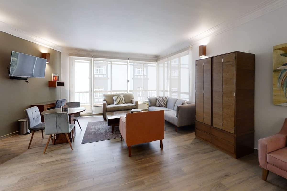 Escritorio, cortinas blackout y tabla de planchar con plancha 