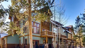 A multi-story log cabin with a balcony, surrounded by snow and trees. - Spacious Private Condo for 6 (Keystone)