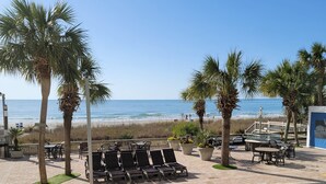 A pool area with lounge chairs and a view of the beach. - Oceanfront Suite, Myrtle Beach SC (Myrtle Beach)