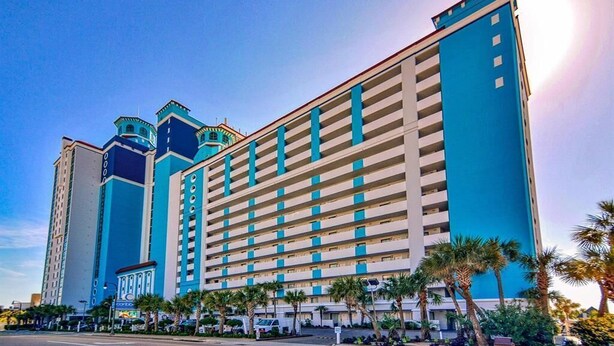 A multi-story hotel with a modern design, featuring a prominent blue and beige color scheme. - Oceanfront Suite, Myrtle Beach SC (Myrtle Beach)