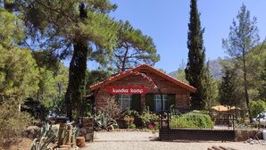 Una cabaña de madera rústica con un letrero rojo que dice "kunduz kamp".