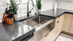 A modern kitchen with a double sink, stainless steel appliances, and wooden cabinets. - Slick Rock Retreat House (Moab)