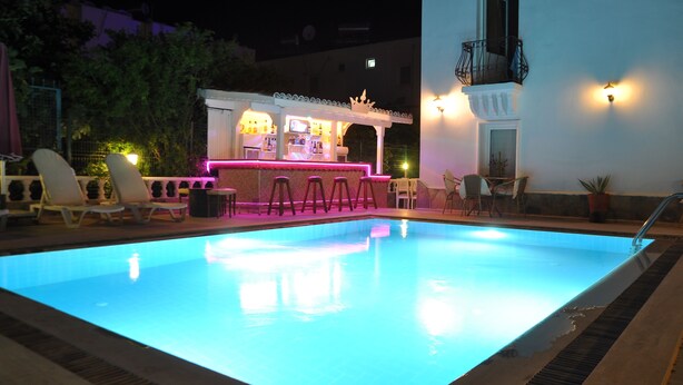 Una piscina con zona de bar y sillones de descanso.