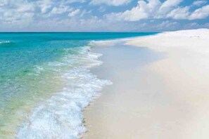 A beach with clear turquoise water and white sand.