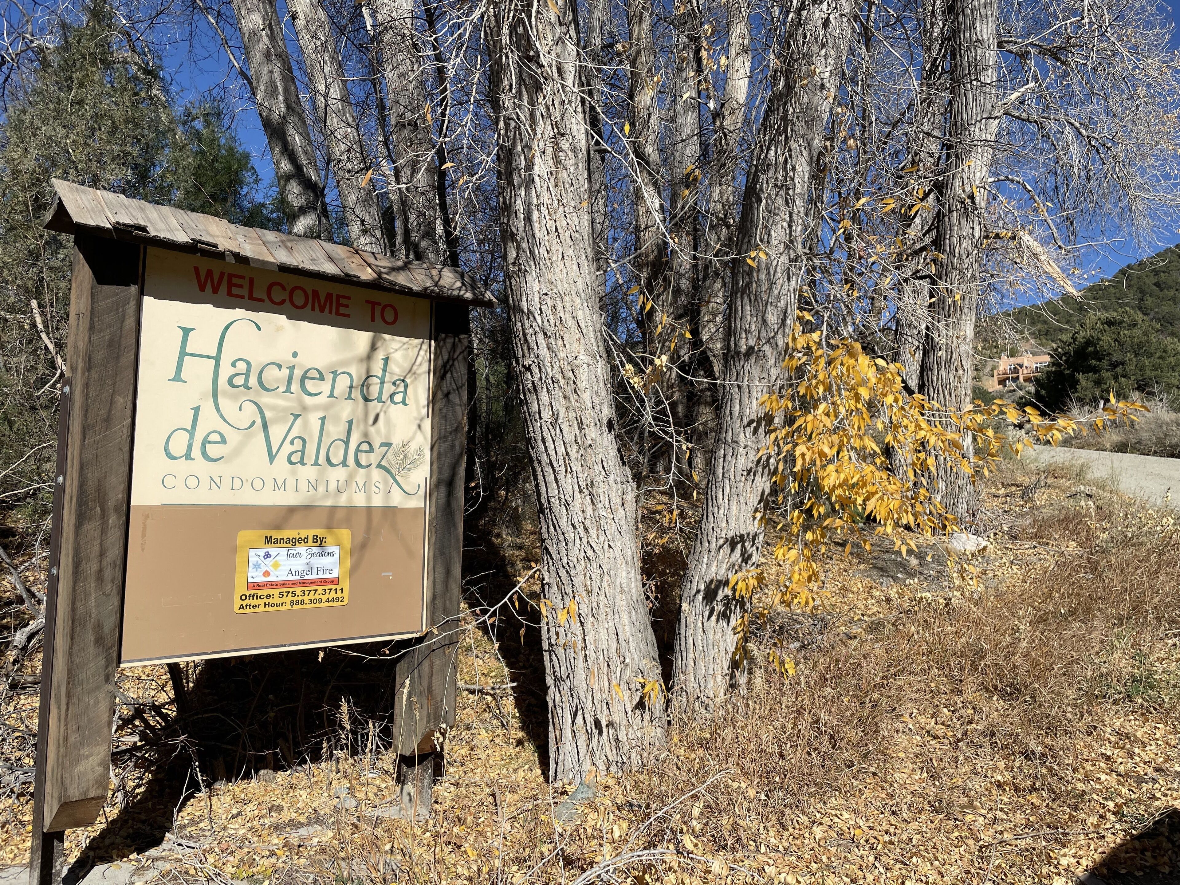 A wooden sign with 'Welcome to Hacienda de Valdez Condominiums' written on it.