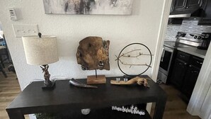 A black console table with a deer head sculpture, a branch decoration, and a small potted plant.