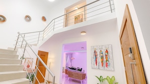 Un intérieur moderne comprenant un escalier, un espace de vie avec un canapé et un coin repas.