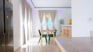 Une cuisine moderne équipée d’un réfrigérateur, d’une table à manger, de chaises et d’un meuble de rangement.
