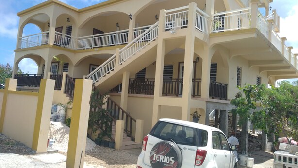 A multi-story building with balconies and a staircase. - Quiet, Spacious and Family Oriented (ANGUILLA)