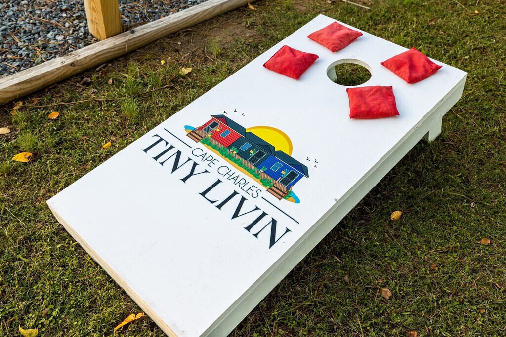 A white board game with a graphic of a house and the text "CAPE CHARLES TINY LIVIN".