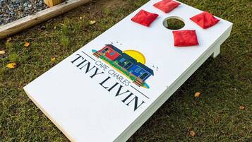 A white board game with a graphic of a house and the text "CAPE CHARLES TINY LIVIN".
