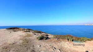 A coastal landscape with a clear sky and calm sea.
