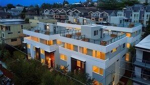A modern multi-story residential building with balconies, large windows, and a flat roof. - 4BR | BBQ, Rooftop | Eastlake | Sophari Home C (Seattle)