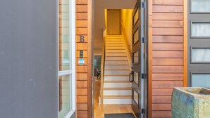 A wooden staircase leading to a room with a door marked 'B'. - 4BR | BBQ, Rooftop | Eastlake | Sophari Home C (Seattle)