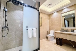 Une salle de bain moderne avec une douche à parois de verre, des toilettes et un meuble-lavabo avec un miroir.