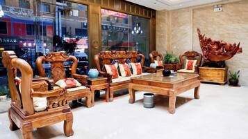 A traditional wooden furniture set with a coffee table, two armchairs, and a sofa.