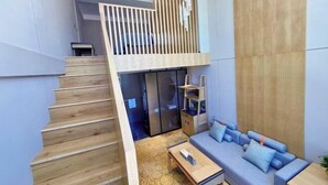 Un interior moderno con una escalera, un sofá y una mesa de centro.