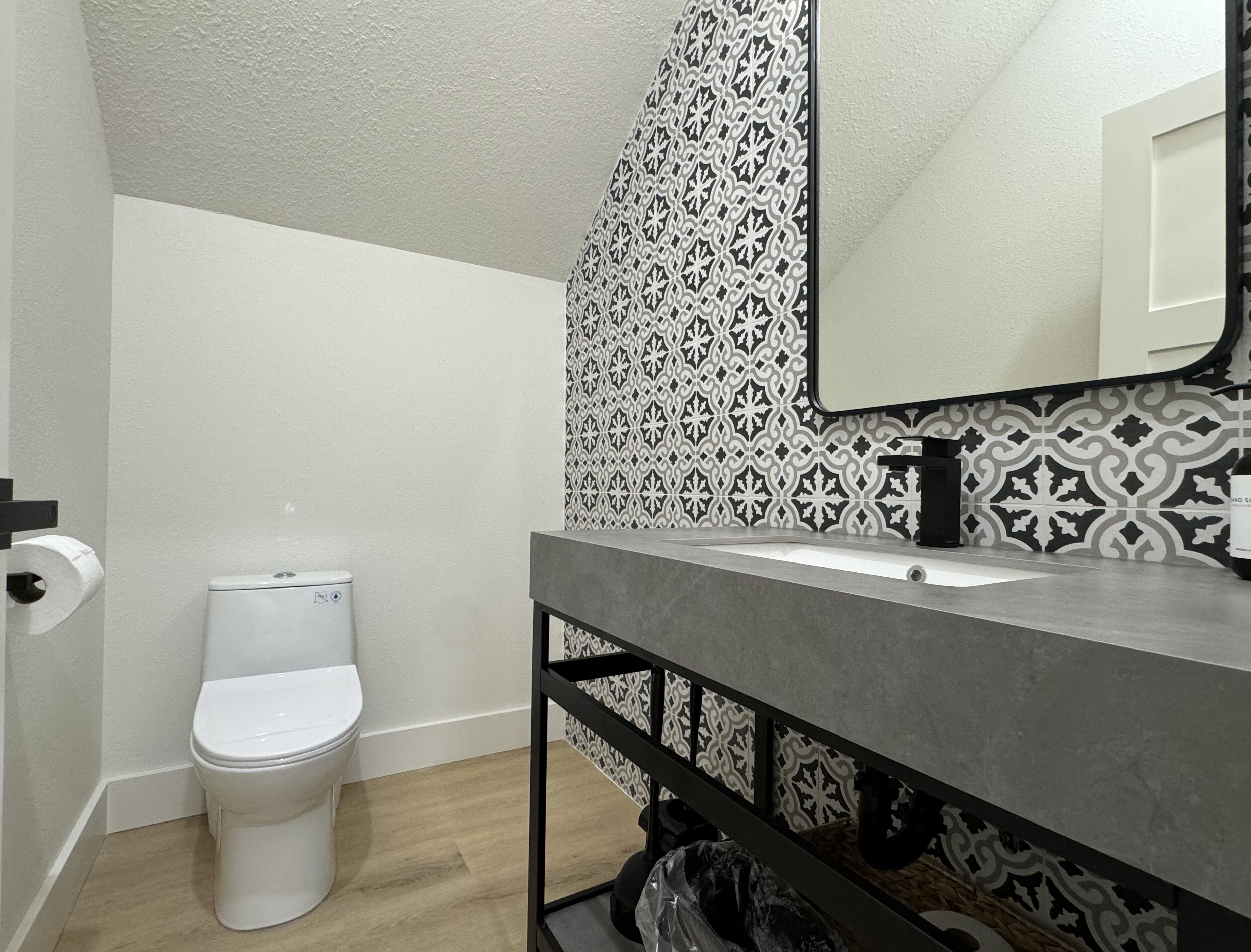 A bathroom with a toilet, a sink, and a mirror.