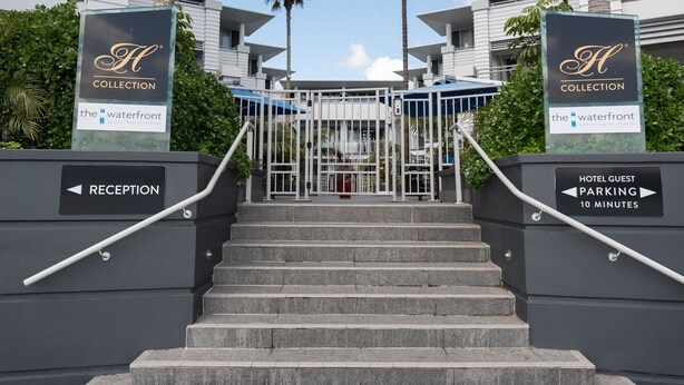 Entrada de un hotel con una escalera que conduce a una zona de recepción vigilada.