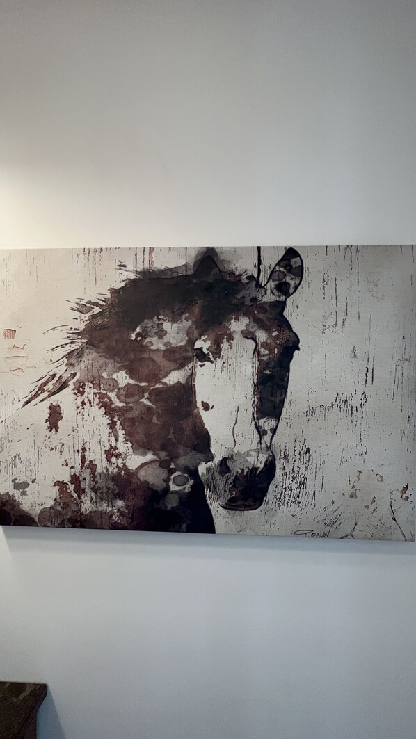 A large abstract painting on a white wall.