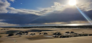A coastal landscape with sand dunes and a beach.