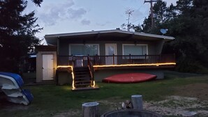 A two-story house with a covered porch, a satellite dish, and a red trampoline in the yard. - Coos bay - Lake house - Direct Dune access - Saunders Lake - Oregon Dunes (North Bend)