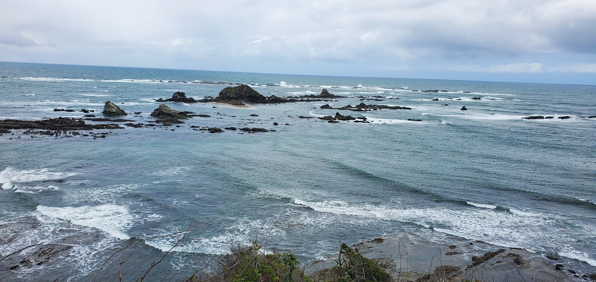 A coastal landscape with rocky outcrops and waves.