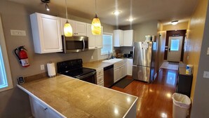 A modern kitchen with white cabinets, stainless steel appliances, and a granite countertop.