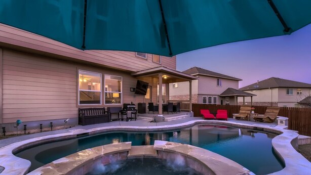 A backyard with a hot tub, outdoor seating, and a covered patio area. - Lxry 4 BR, Heated Pool/Spa, Large Game Room, near Seaworld/Six Flags (St1) (San Antonio)