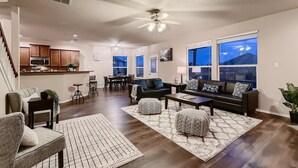 A spacious living room with a dining area, kitchen, and large windows. - Lxry 4 BR, Heated Pool/Spa, Large Game Room, near Seaworld/Six Flags (St1) (San Antonio)