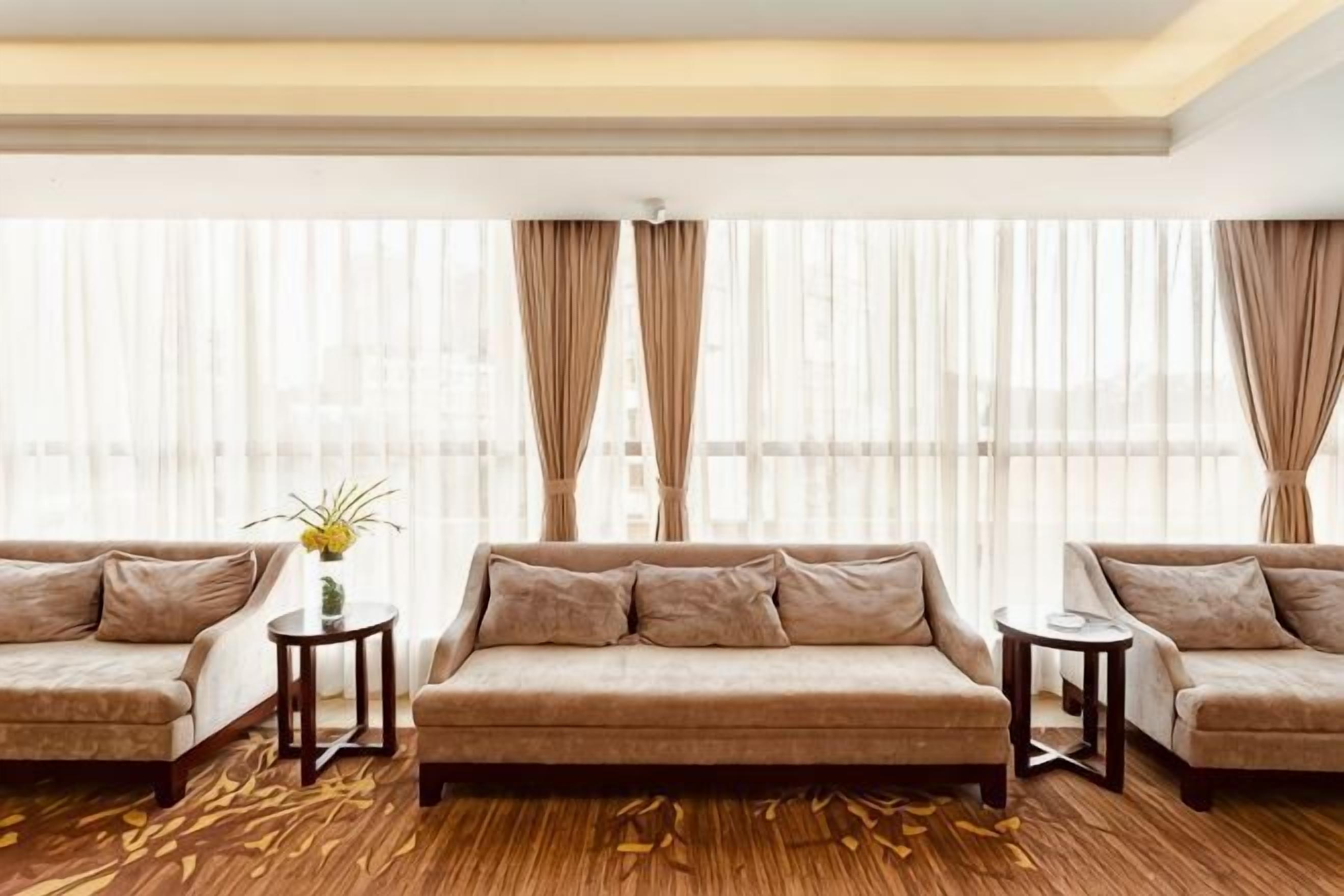 A modern living room with two sofas, a small table, and a vase with flowers.