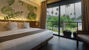 A hotel room with a large bed, a view of palm trees, and a balcony with outdoor furniture. - Isla Amara Resort (El Nido)