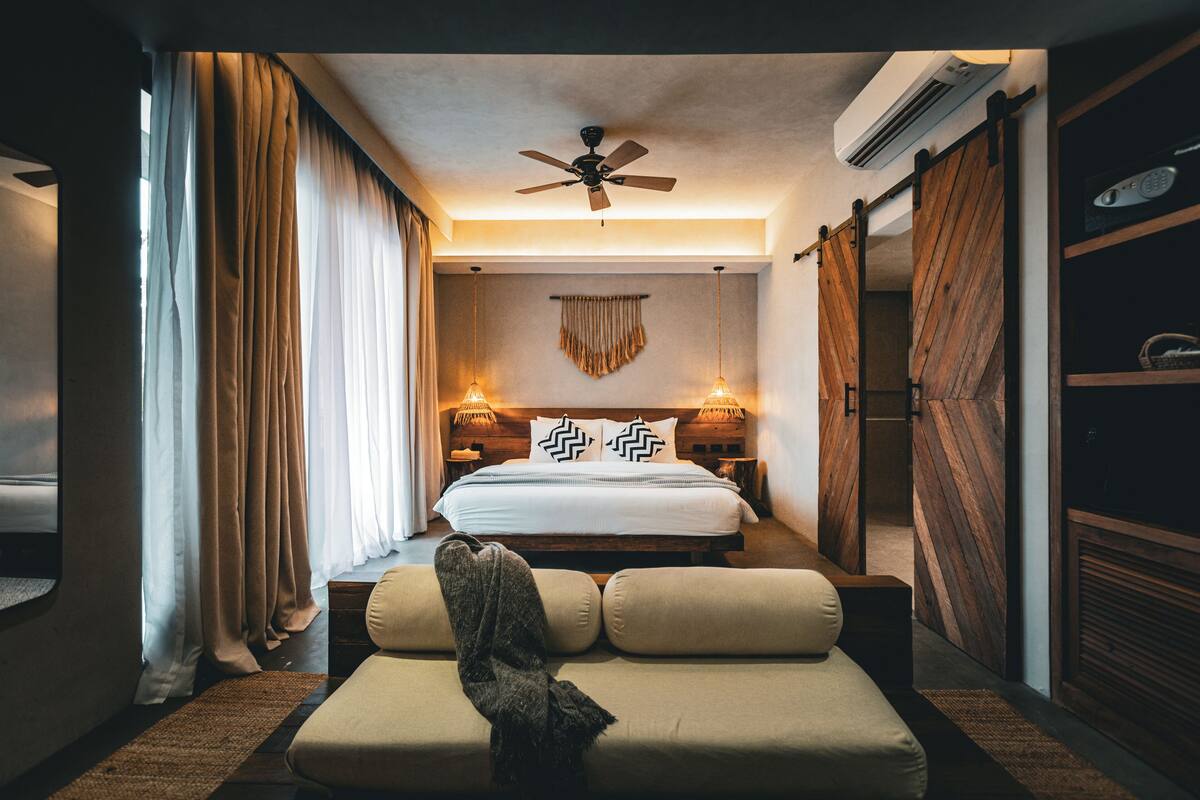 Ein Hotelzimmer mit Bett, Sofa, Deckenventilator und Kleiderschrank.