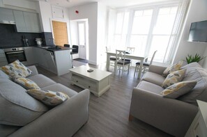 Relax in a spacious living area with a sofa set, coffee table, and dining table, perfect for unwinding and dining.